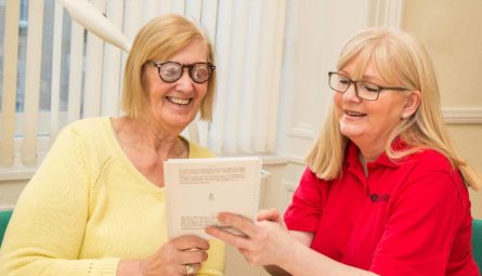 Photo of our worker demonstrating eccentric reading to a service user