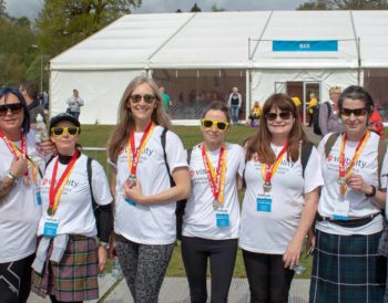 Smiling Visibility Scotland fundraisers with their medals after the Kiltwalk