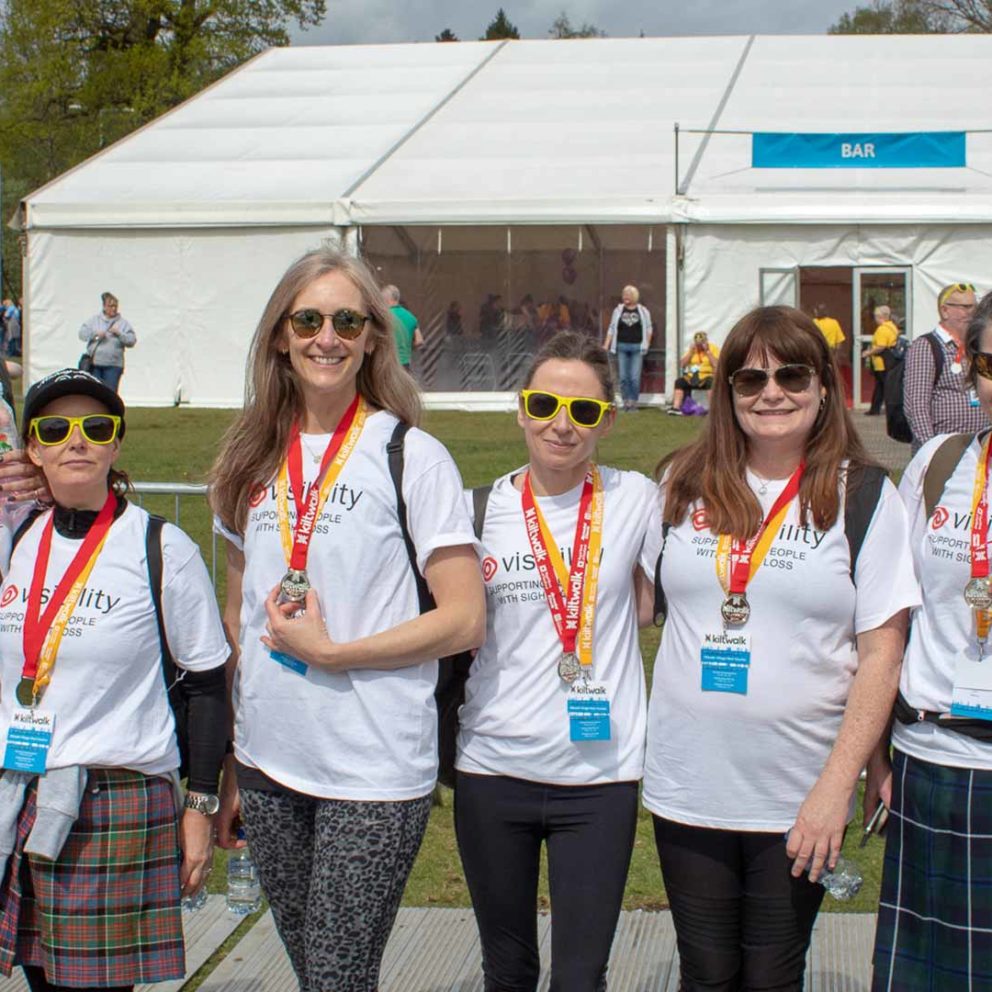 Smiling Visibility Scotland fundraisers with their medals after the Kiltwalk