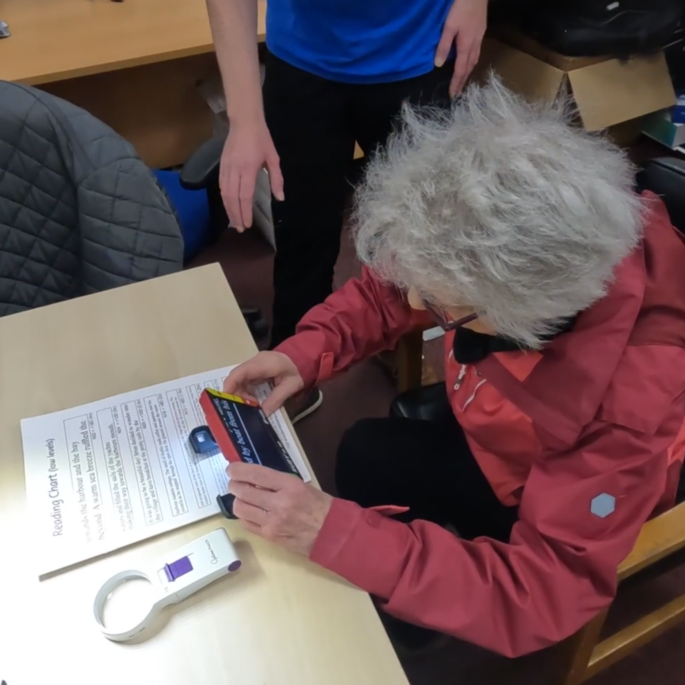 A service user uses a Ruby digital magnifier in our digital suite to read some text.