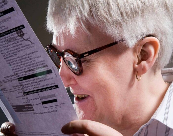 Picture of a woman with glasses demonstrating eccentric reading