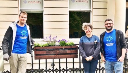 3 volunteers from Mrogan Stanley showing off the flower box outside our office