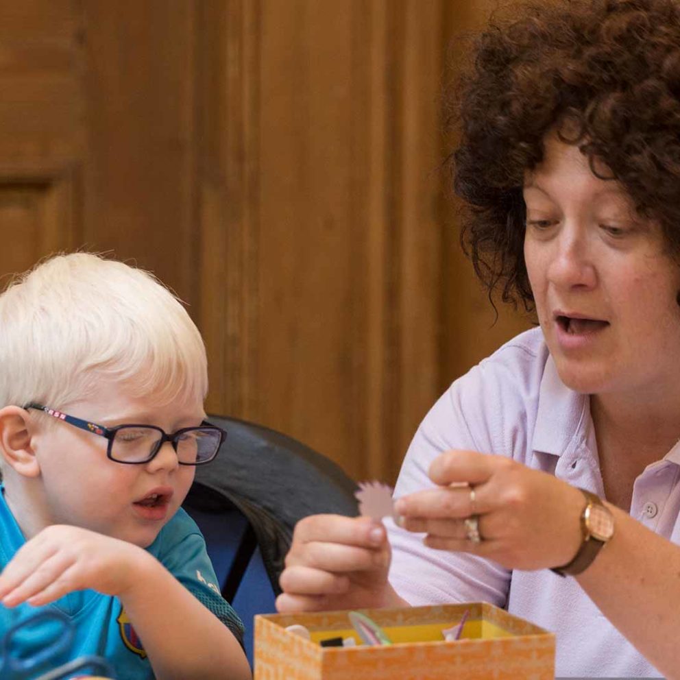 Visiblity Scotland worker and young child looking at art materials