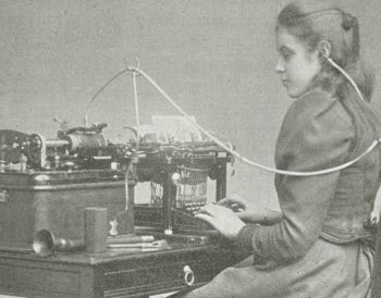 Historic photo from the 19th century showing a young woman at a typewriter