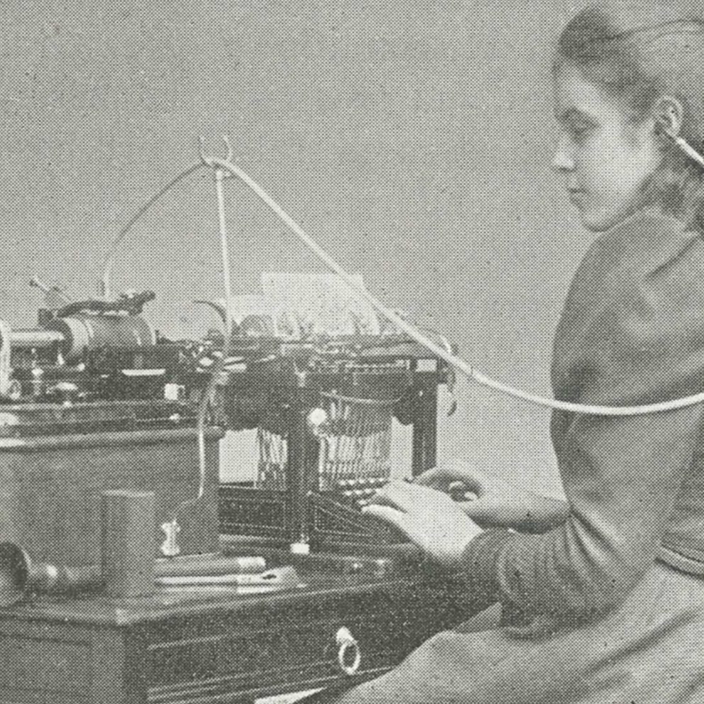 Historic photo from the 19th century showing a young woman at a typewriter