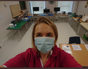 Our CEO, Laura Walker, wearing a face mask in our resource centre at Queen&#039;s Crescent. Aids and equipment for demonstration are placed around the room.