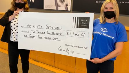 Visibility staff member, Jeni, collecting a cheque from John Lewis for £2,145.
