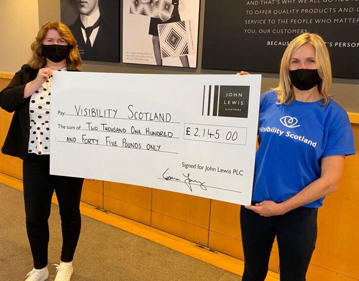 Visibility staff member, Jeni, collecting a cheque from John Lewis for £2,145.