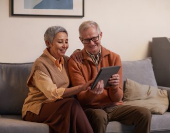 A couple on a couch using a tablet computer