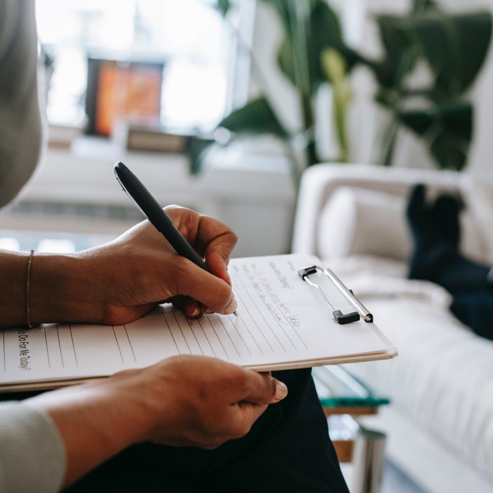 Close up of a woman filling out a form on a clipboard