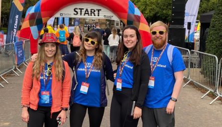 Our fundraiser, Louise, and three of her friends smiling and wearing Visibility Scotland t-shirts at the start of the Kiltwalk.