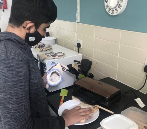 Muhammed making a toastie in our accessible kitchen