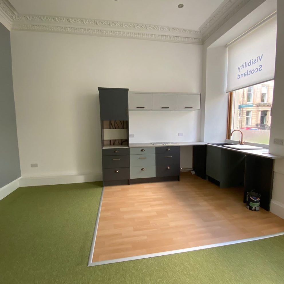 One of the meeting rooms in our Glasgow office in the process of being transformed in to a one bed flat. The walls and ceiling have been plastered and painted, new lights fitted and new flooring installed. There is a kitchenette in the corner.