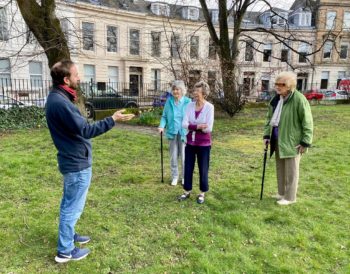 David from RSPB talking to three participants at our Spring birdsong event in the garden at Queen&#039;s Crescent.