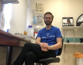 Alister Lees, patient support worker, sitting on a chair in the patient support room at Gartnavel Hospital.