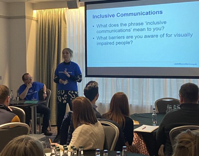 Two Visibility Scotland team members delivering a session n Inclusive Communications to a group of community optometrists.