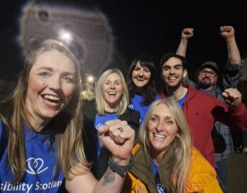 Six members of the Visibility Scotland firewalk team celebrate at the end of the firewalk