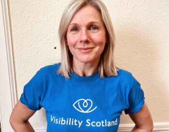 Jeni Queen, Trainee Visual rehabilitation specialist, smiles while wearing a blue Visibility Scotland t-shirt