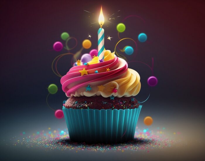 A multi-coloured birthday cupcake with a single candle on top of it
