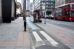 A cycle track running behind the bus stop on a busy city street
