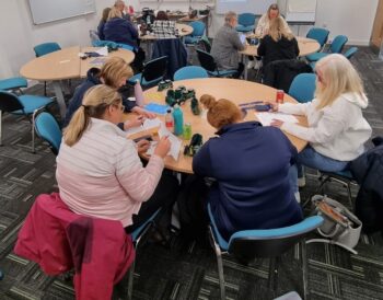 Groups of people sitting around tables taking part in a quiz on Visual Impairment