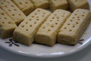 A close-up of several shortbread biscuits on a white patterned plate