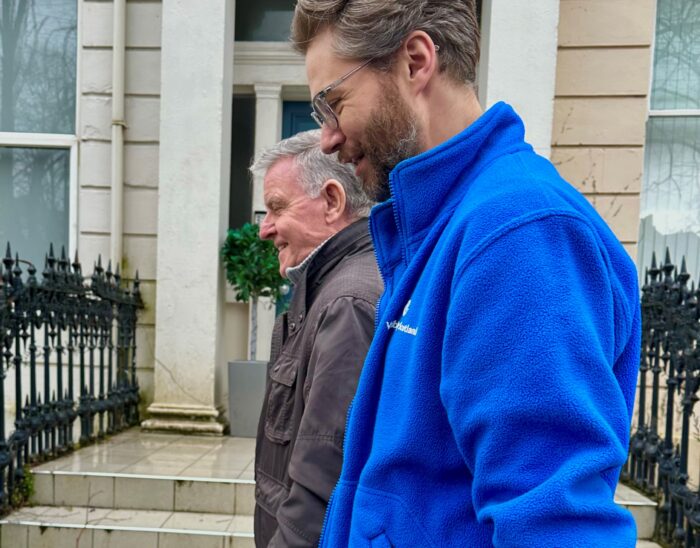 Alister Lees, Assistant neurological Vision rehabilitation Specialist, teaching outdoor scanning to a gentleman outside Visibility Scotland's headquarters.