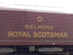 The side of a brown train car with the words "Belmond Royal Scotsman" printed on it
