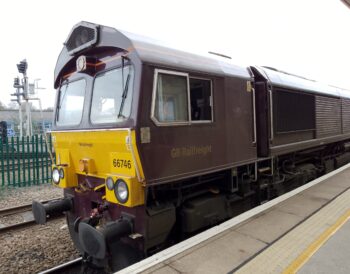 The engine of a dark purple and yellow GB rail freight train