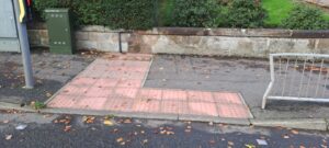 red blister paving in an L-shape next to a controlled crossing