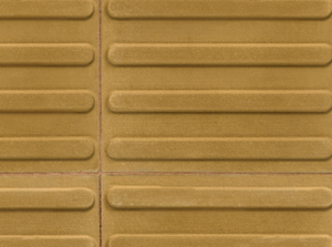 Close-up image of tan guidance paving with raised horizontal areas acting as guidance. 