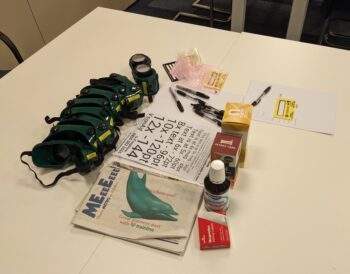 Simulation goggles and reading materials lay on a white table
