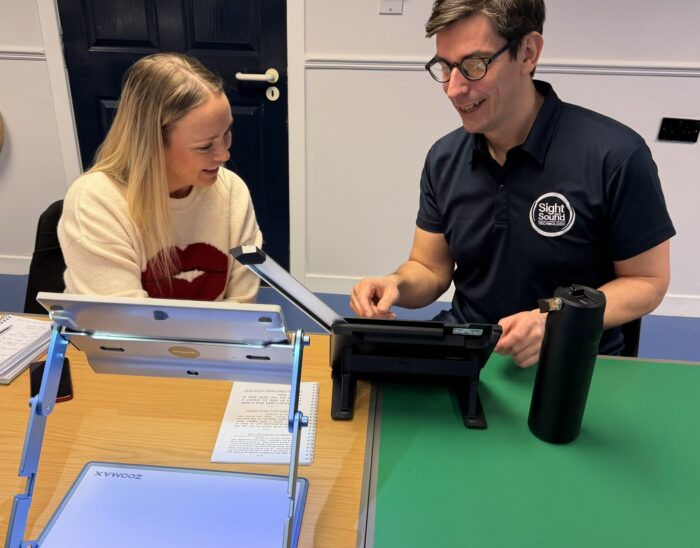 An instructor from Sight and Sound Technology trains a Visibility Scotland staff member to use a digital magnifier
