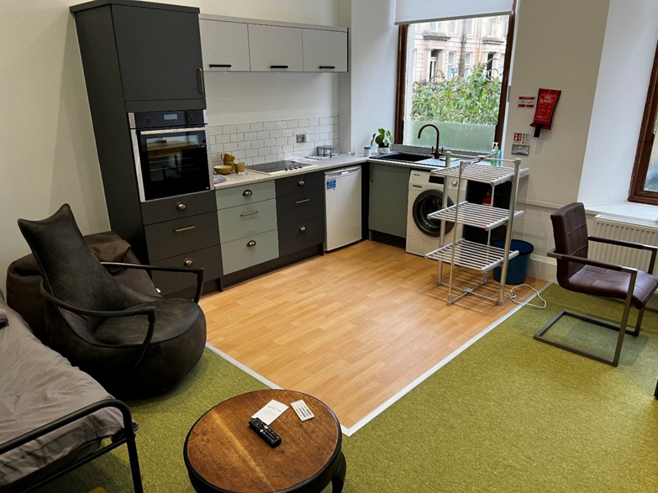 Modern Independent Living Flat with a fully equipped kitchen area, seating, bed and seating area.