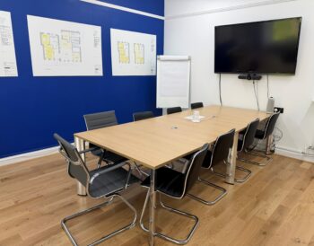 Visibility Scotland's meeting room for hire with black chairs arranged around a large wooden table.