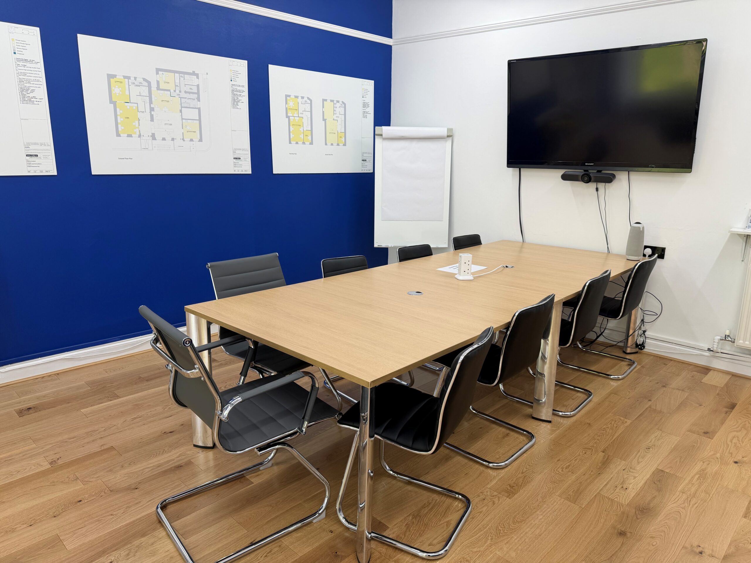 Visibility Scotland's meeting room for hire with black chairs arranged around a large wooden table.
