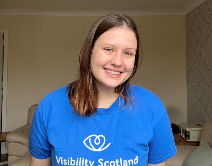 August smiles at the camera, she is wearing a blue Visibility Scotland top.