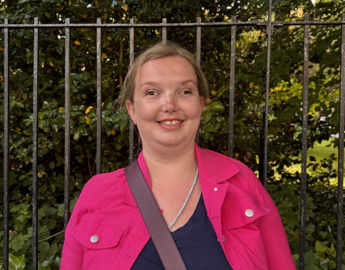 Board member Natalie stands outside smiling