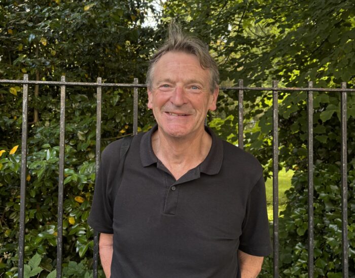 Board member Neil stands outside smiling