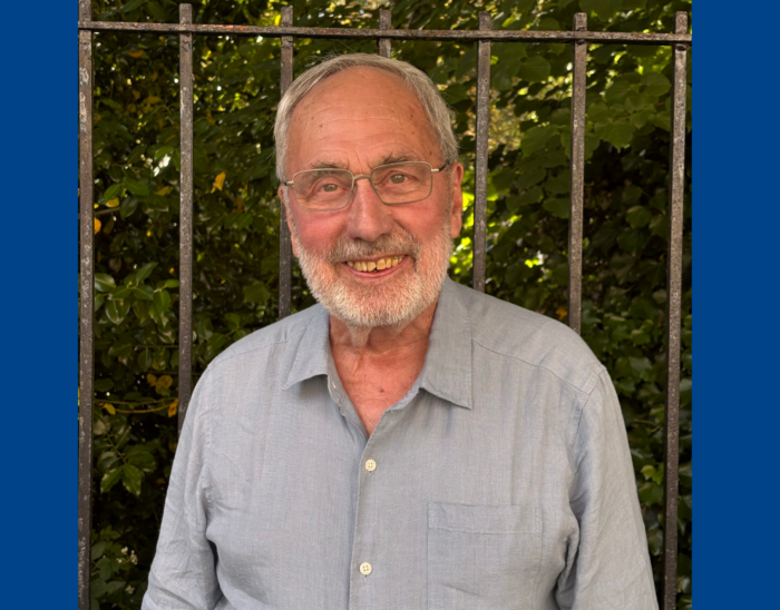 Board member Howard stands outside smiling.